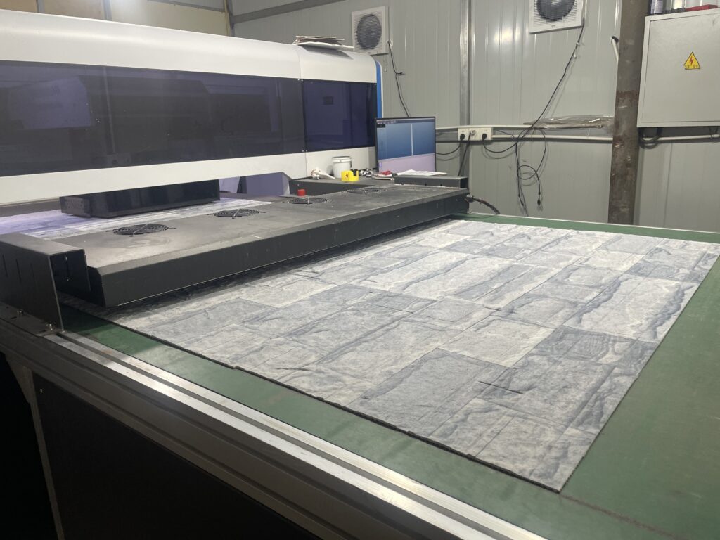CNC machine cutting flexible stone veneer panels at the JMS Decor factory