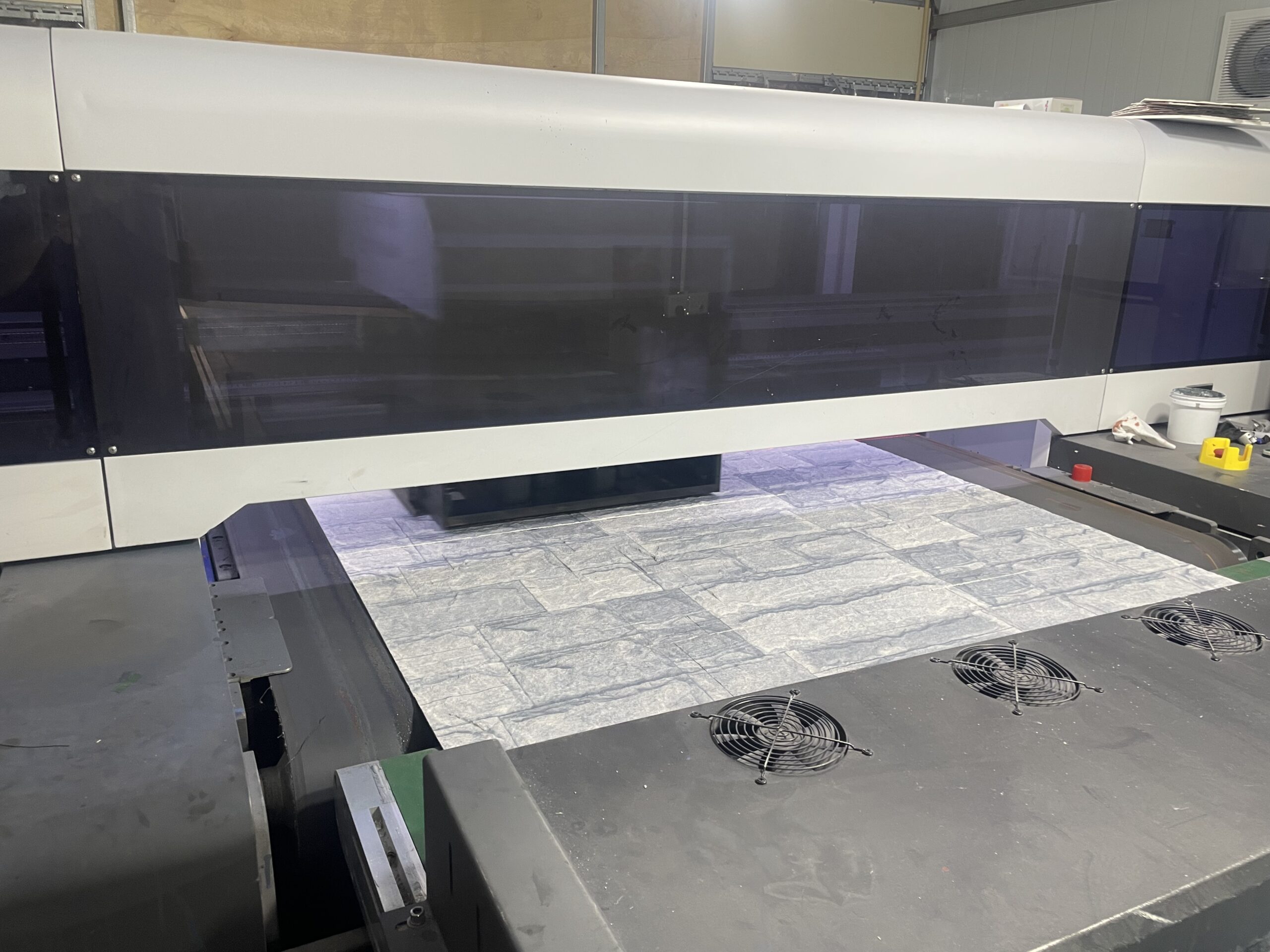 Factory production line applying a flexible stone finish to a prefab panel