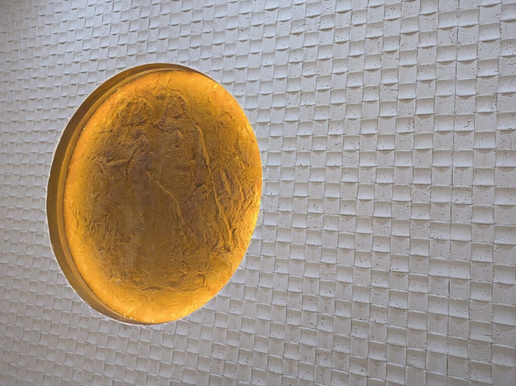 Travertine style flexible stone wall panel with circular warm light detail